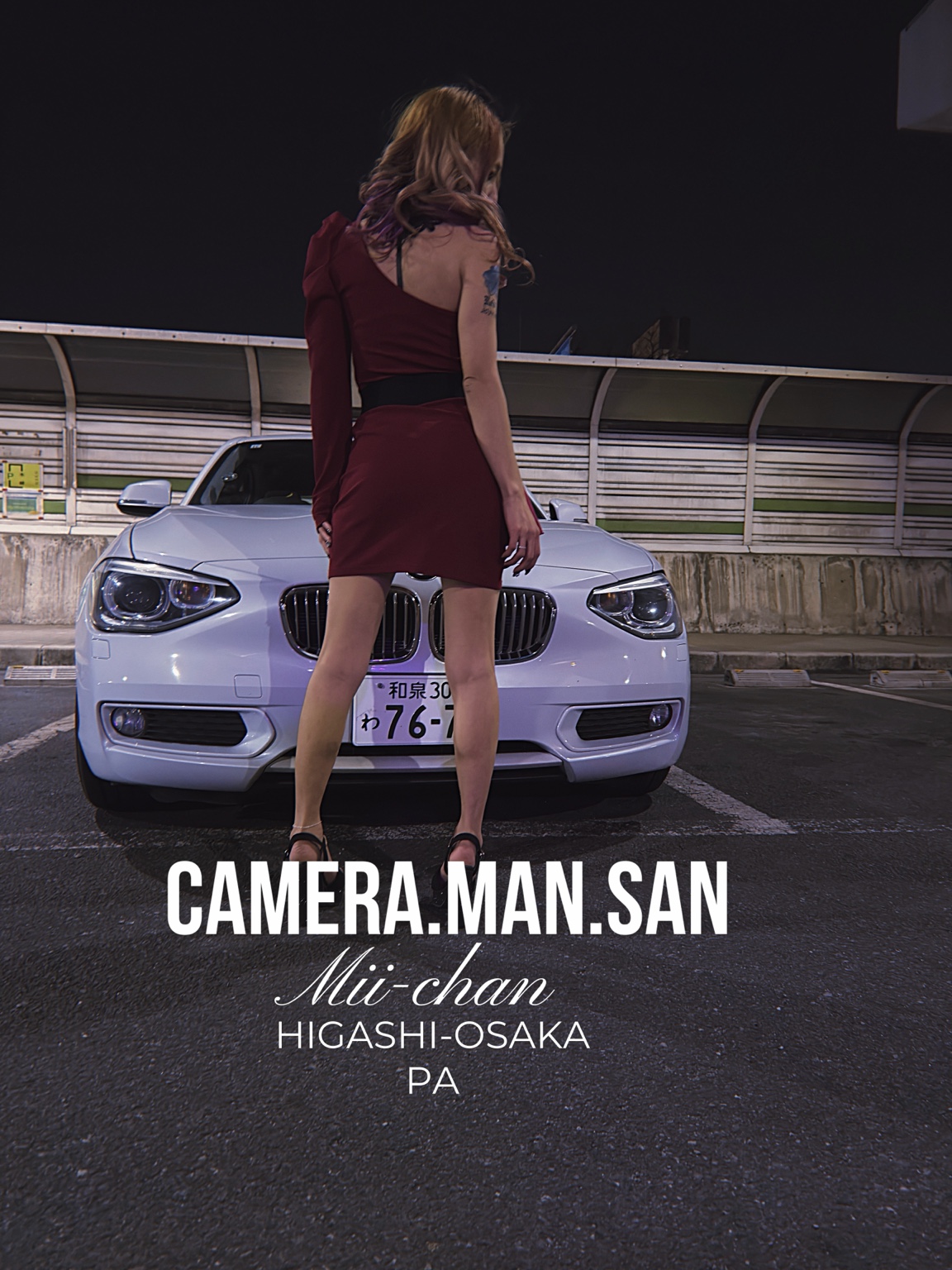 Portrait looking away in front of a white BMW at night