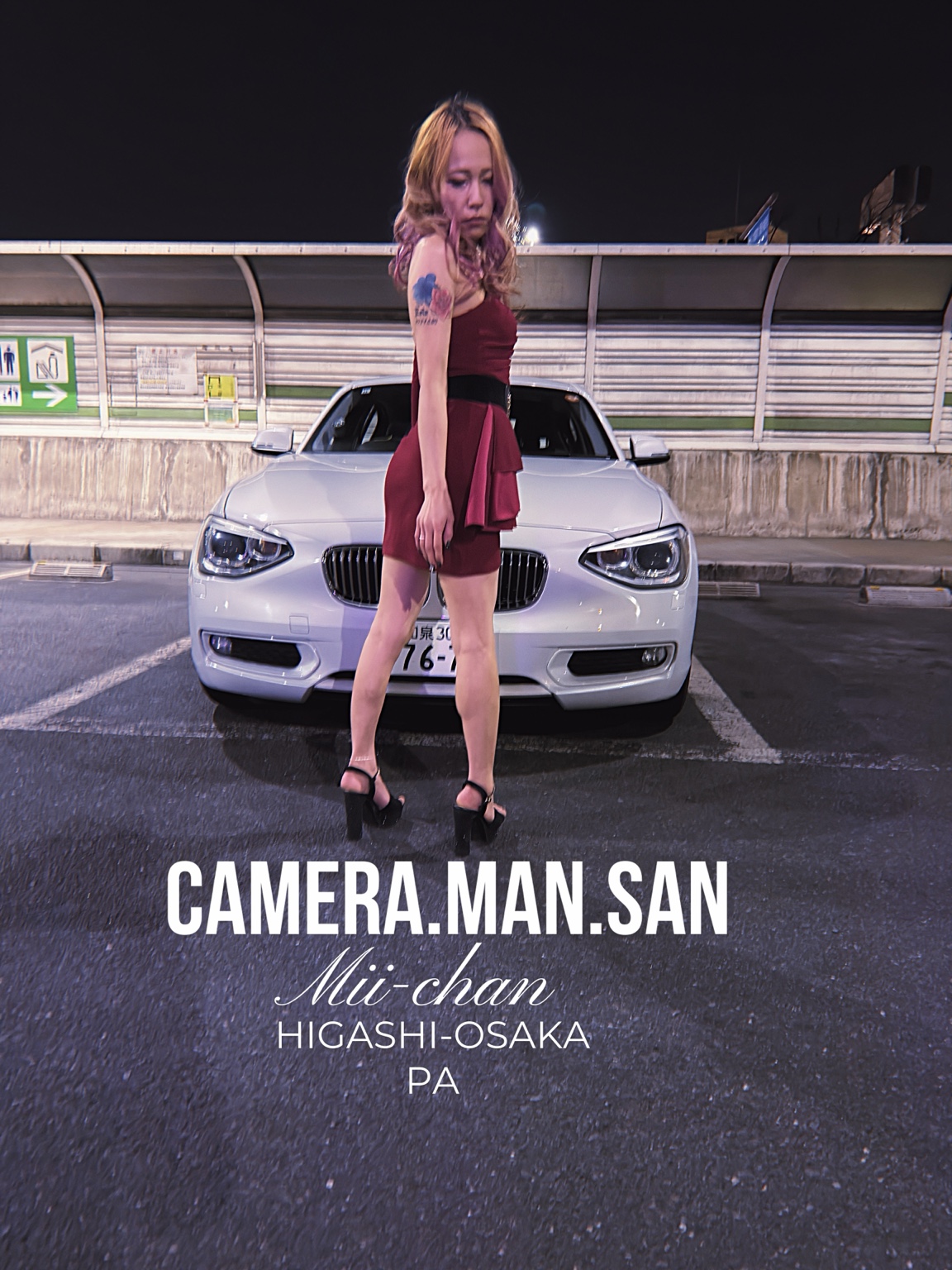Portrait standing in front of a white BMW at night