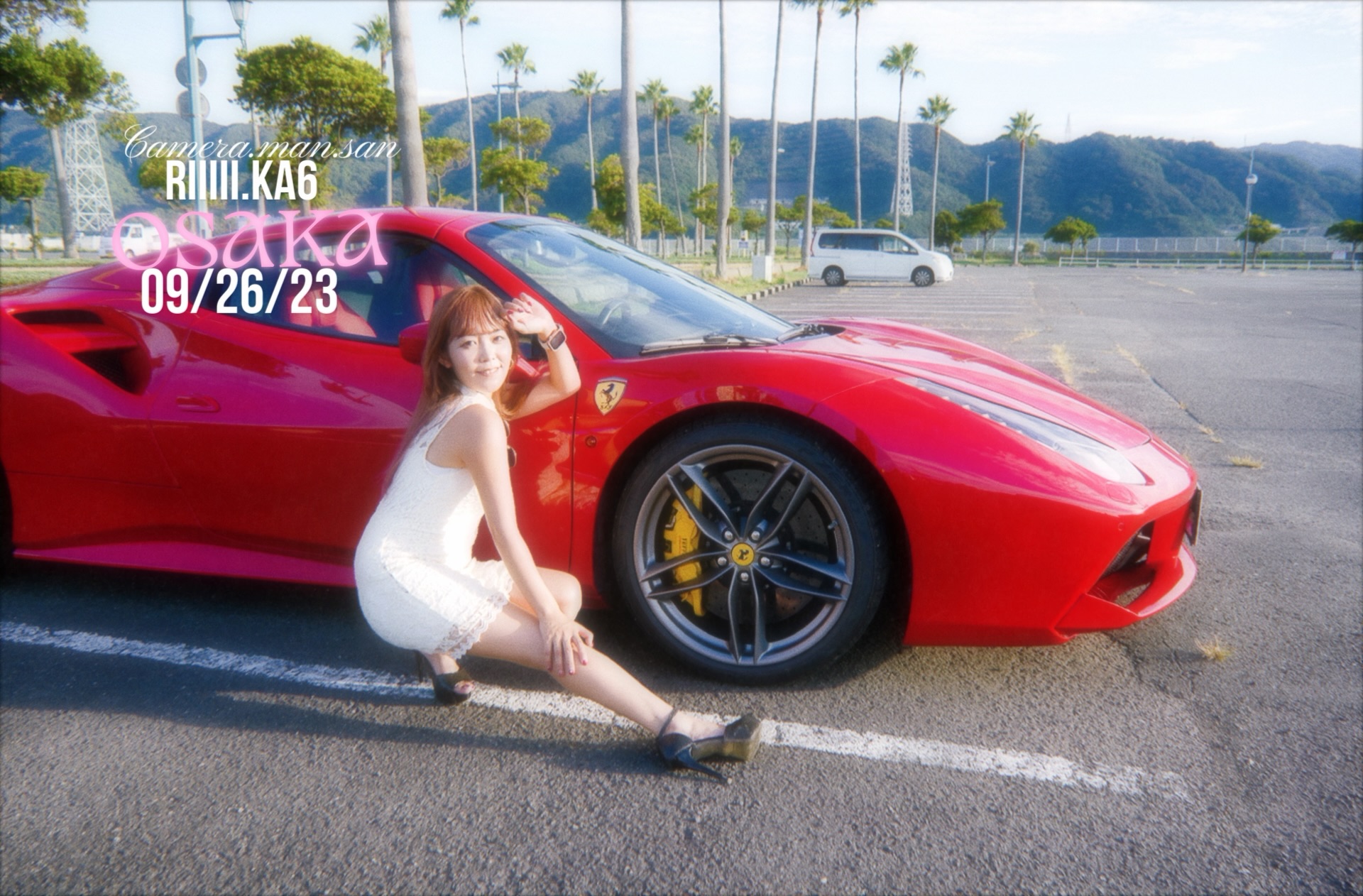 Portrait beside a red Ferrari in an outdoor parking lot