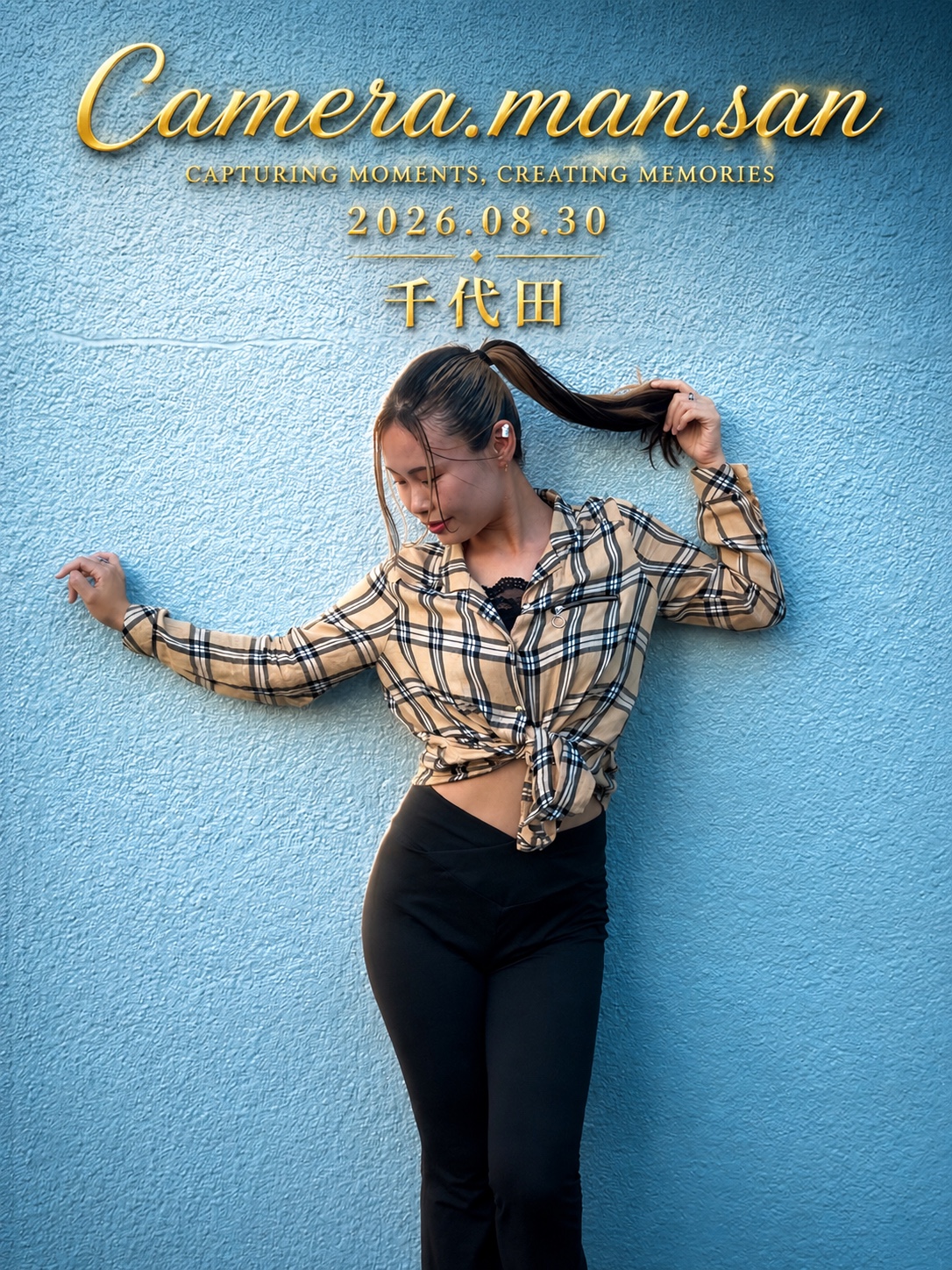 Portrait looking down and holding a ponytail against a blue wall