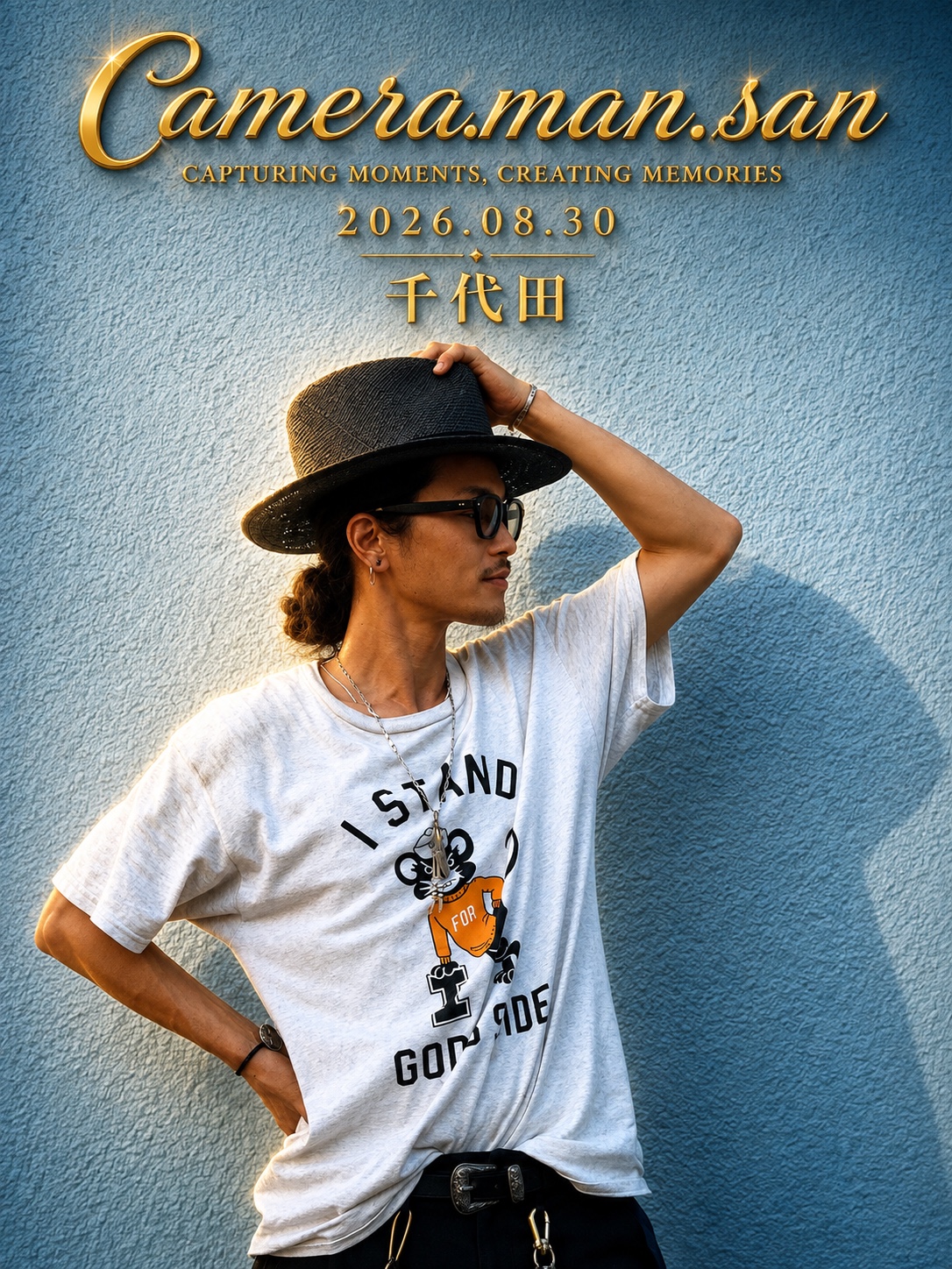 Portrait wearing a black hat and sunglasses against a blue wall